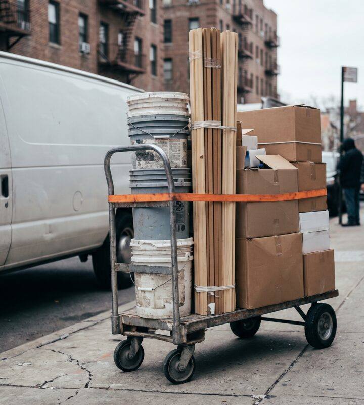 Contractor supplies loaded on a hand truck beside a delivery van in Manhattan